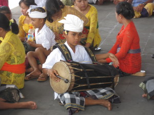Little local boy drumming at a temple performance