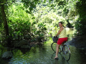 Biking through the mini river to the fishing village